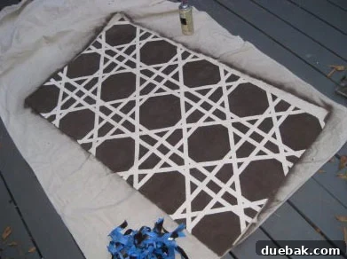 The finished DIY spray painted rug with a bold geometric pattern, showcasing the successful transformation.