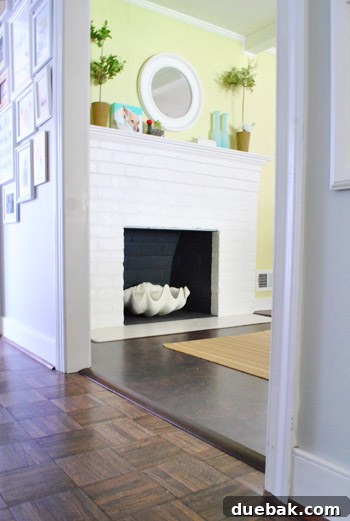 View from the hallway showing a newly installed doorway transition and the fireplace with its giant faux clam shell.