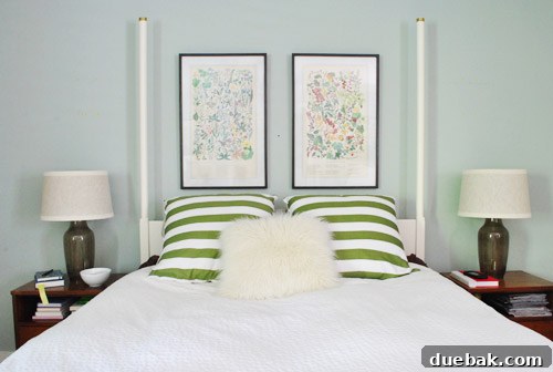 The two botanical prints now perfectly hung above the bed, showcasing the final, precise spacing and alignment.