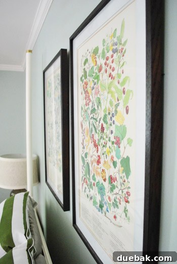 A side view of the bed and the newly hung prints, providing another perspective on the room's refreshed decor.