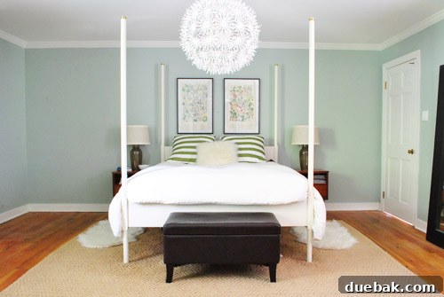 A wide shot of the bedroom, showing the bed and newly hung art in a still mostly empty room, hinting at future decor plans.