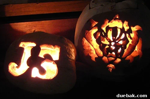 ourjackolaterns Hand-carved jack-o'-lanterns lit up at night, creating a festive Halloween ambiance on a porch.