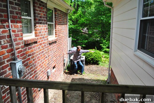 Person demonstrating the height of the proposed deck floor, showing how it will block the view of utilities.