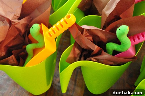 Earthworm Extravaganza Birthday 12 Parent holding a watering can party favor with a stuffed 'worm,' expressing a desire to keep one.