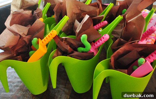 Earthworm Extravaganza Birthday 9 Worm-themed party favors: green watering cans filled with bubbles, scoops, and 'worms' (transformed snakes).