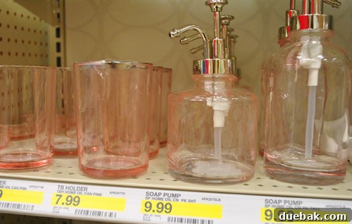 Soft pink glass bathroom accessories, including soap pumps, for a delicate and serene look.
