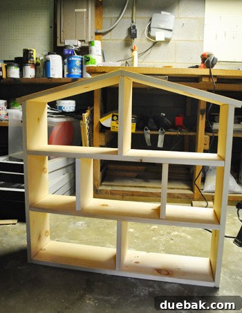 Partially completed dollhouse structure with roof installed