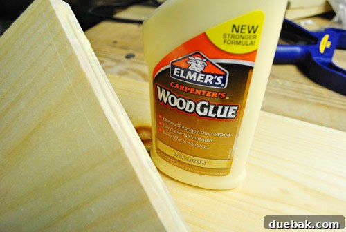 Applying wood glue to a dollhouse wall segment before assembly