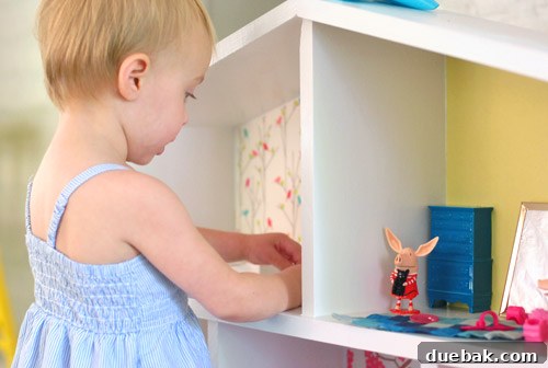 Pint-Sized Palaces: Decorating Your Dollhouse 29 Close Up of Little Girl Playing With Olivia Pig Figurines In Homemade Dollhouse