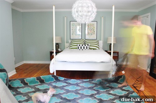 John vacuuming the bedroom floor with enthusiasm before placing the new rug.