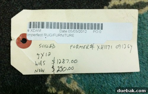 Price tag showing a significant discount on a rug, from $1287 to $250.