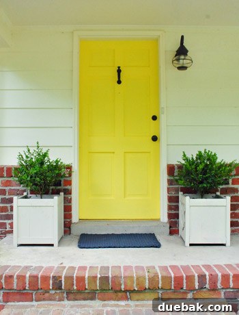 Boxwoods newly replanted in the wooden planters on the front porch, enhancing curb appeal.