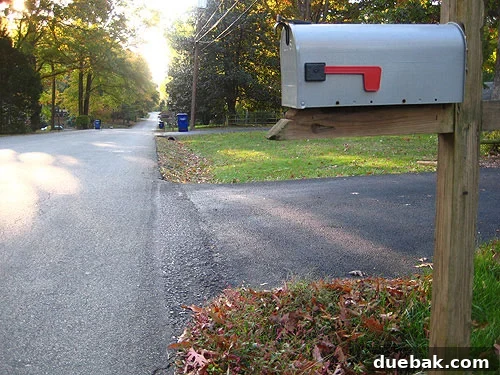 Bins for waste, recycling, and compost at a driveway