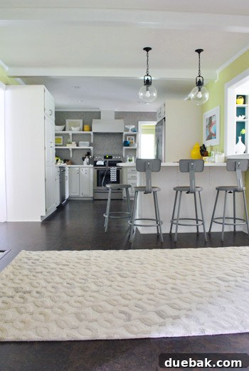 A light Pottery Barn rug from the home office being tried in the kitchen