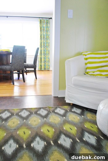 Ikat rug showing potential coordination with dining room curtains, styled with a dishcloth pillow cover