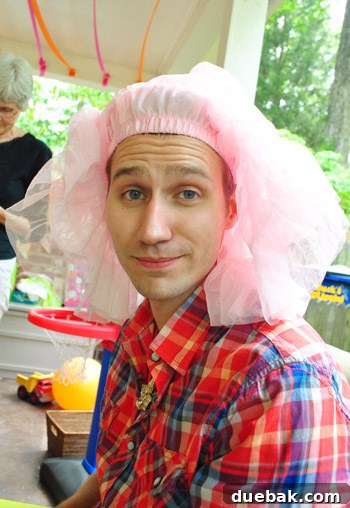 Dad wearing a ballerina skirt on his head at a birthday party