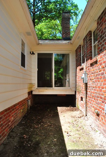 Reclaiming Space: From Balcony to Spacious Deck 13 The empty space on the house wall after balcony removal, featuring a sliding door that now opens to open air