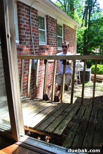 Reclaiming Space: From Balcony to Spacious Deck 3 Close-up of a person actively pulling and twisting the old balcony railing, demonstrating the unexpected speed of demolition