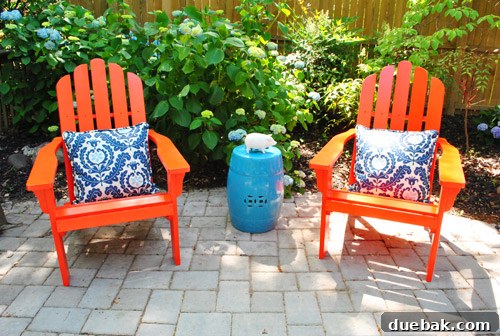 Bringing a Pop of Color to Our Side Patio with Red Adirondacks 5 Two vibrant red Adirondack chairs on a paver patio with blue hydrangeas