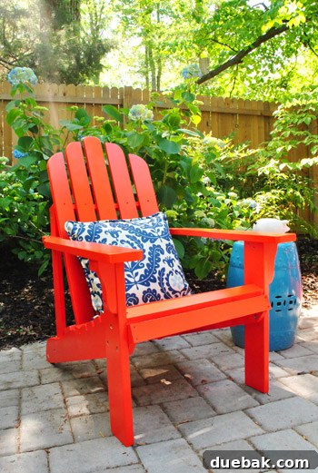 Bringing a Pop of Color to Our Side Patio with Red Adirondacks 6 A single vibrant red Adirondack chair on a paver patio