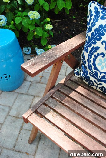Bringing a Pop of Color to Our Side Patio with Red Adirondacks 8 Close-up of a weathered wooden folding chair showing wear and tear