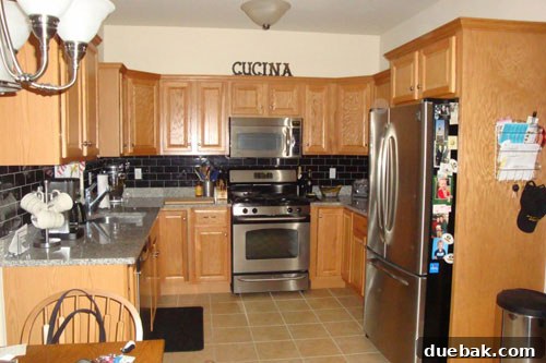 Carla's traditional kitchen with wooden cabinets and dated decor before renovation