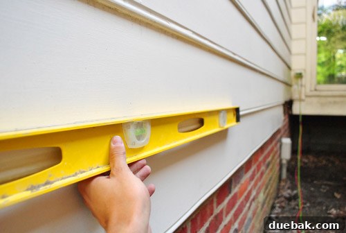 Sourcing Your Deck Building Materials 20 Marking a straight line on the wood siding for cutting