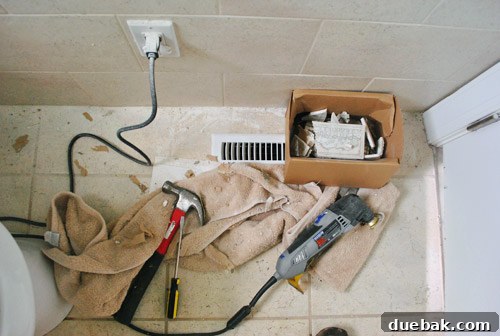 Debris and dust covering the bathroom floor during the messy tile removal process