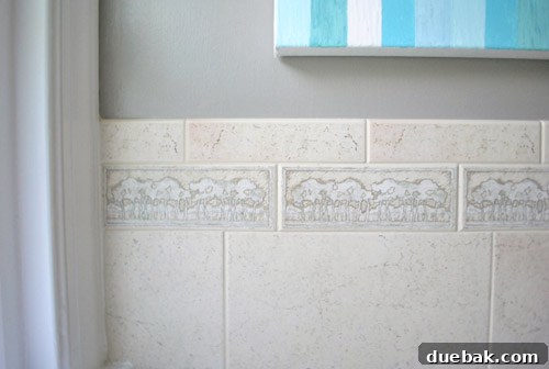 Close-up of the repetitive tree pattern on the old, dated beige bathroom border tile