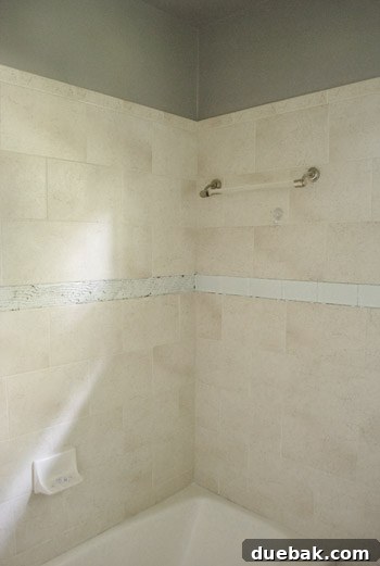 Scoring a clear glass tile with a manual tile cutter to prepare for a straight cut
