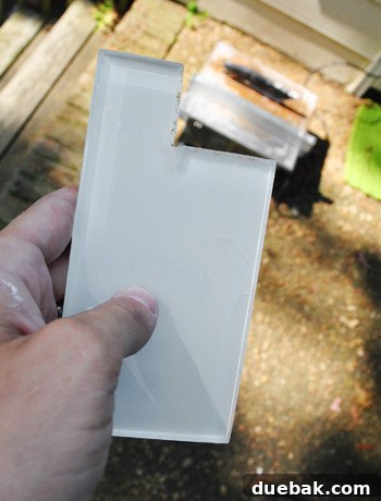 Two glass tiles perfectly cut with a wet saw, ready for installation around a light switch