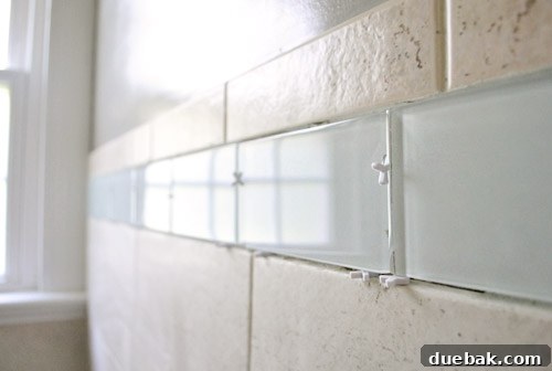 Mixing antique white grout for the bathroom tile installation, aiming for a consistent texture