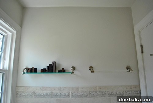 Before shot of the dated bathroom interior with the old tree border visible