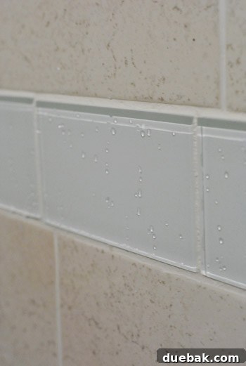 Clear glass tiles showing subtle blue-green reflections from nearby art, highlighting their adaptability