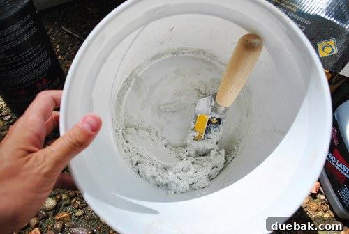 Applying thinset mortar evenly to the bathroom wall using a trowel
