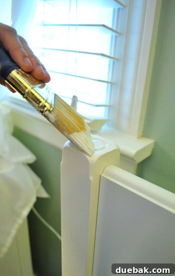 Painting step: Applying Ikea-white paint to the sanded bedpost for a cohesive finish.