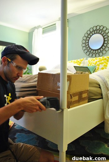 Safety precaution: A piece of cardboard placed between the mattress and the bedpost to protect it during cutting.