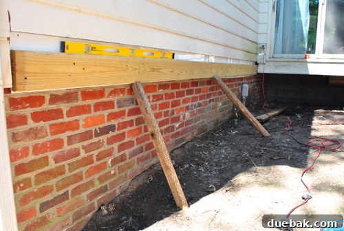 Installing the second ledger board on the house siding