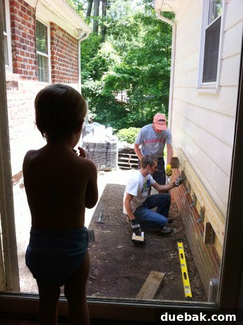 Child observing deck construction from doorway