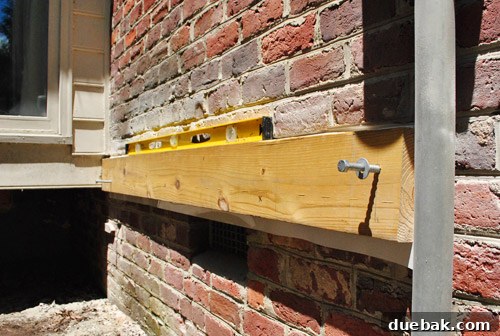Ledger board attached to brick veneer, which was deemed non-compliant