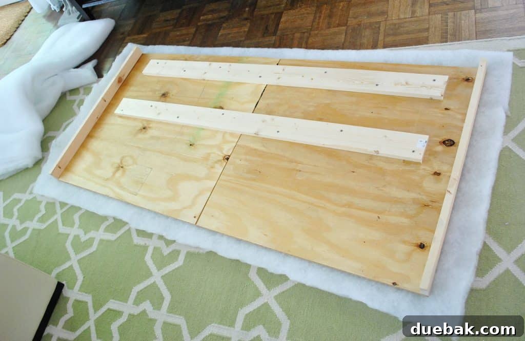 Layer of batting placed under DIY headboard wood frame, ready for attachment