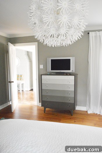 Why Your Bedroom Needs A TV Now 2 A serene bedroom setup featuring a dresser with a mounted TV, hinting at relaxation and modern comfort.