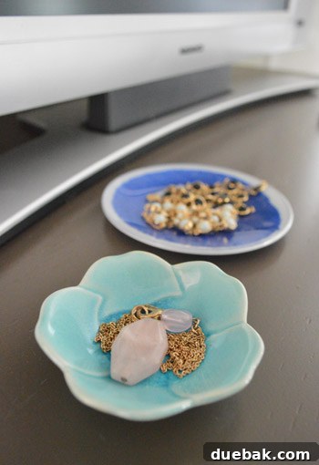 Why Your Bedroom Needs A TV Now 9 Close-up of decorative jewelry dishes on the dresser, showcasing personal style.