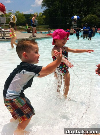 Family enjoying a sunny day at a public pool with water slides