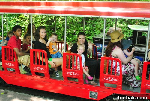 Two children riding a miniature train at the zoo