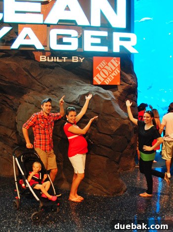 Group of friends posing next to a Home Depot logo in an aquarium