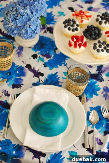 Overhead view of the elevated Fourth of July table setting, showcasing flipped blue bowls as potential treat covers.