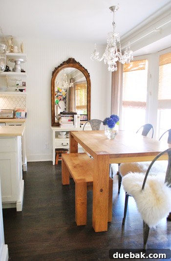 Vibrant Home Breakthrough 13 Dining area with Crate & Barrel table, bench, chairs, and a secondhand chandelier.