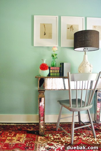 Vibrant Home Breakthrough 15 Guest room featuring a red rug, teal walls, and an Anthropologie vase on the desk.