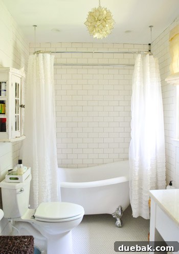 Vibrant Home Breakthrough 20 Luxurious master bathroom with a freestanding tub, penny tile floor, and ruffled shower curtains.